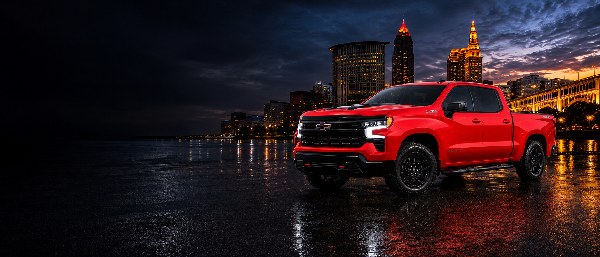 Red Chevy Silverado with Cleveland skyline at dusk